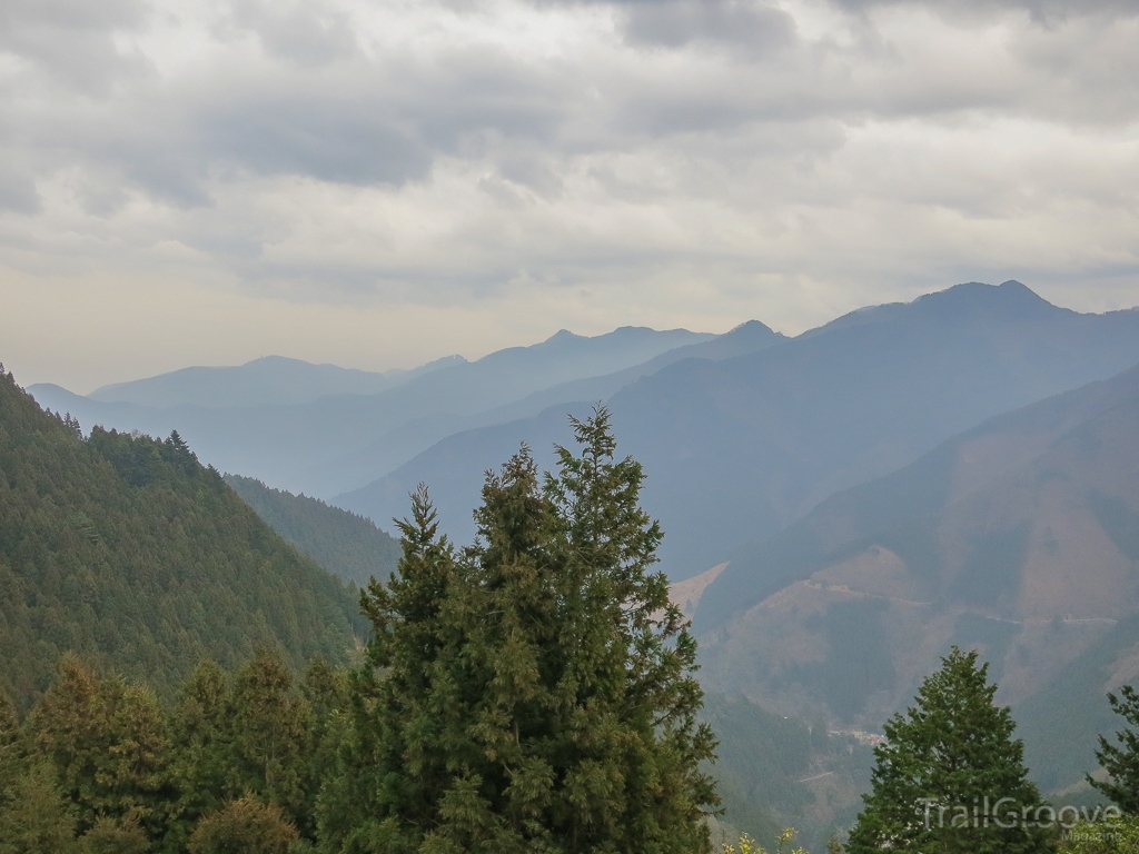 As you start to make your way out of the woods, you can catch a brief glimpse of the town of Okutama below you, nestled in the folds of a long row of mountains